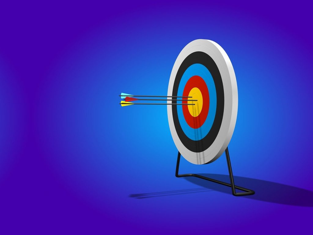 An archery target board, with 3 arrows stuck in the center - a cyan one, a yellow one and a red one.
