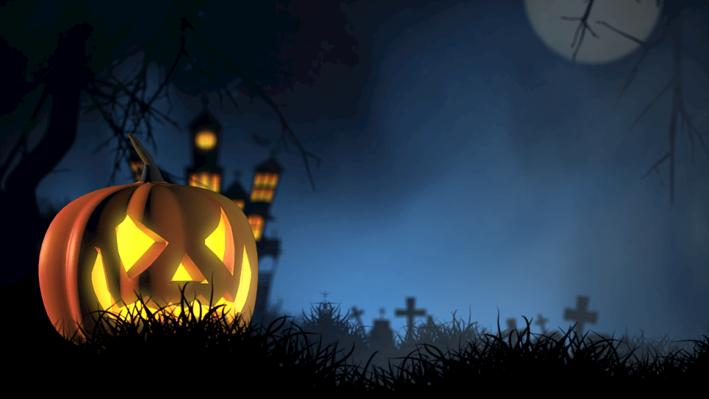 A Pumpkin Jack-O'-Lantern glowing in the foreground with a graveyard full of crosses in the background and a creepy mansion lit up behind it.